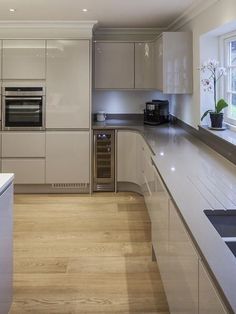 a modern kitchen with stainless steel appliances and wood flooring is pictured in this image