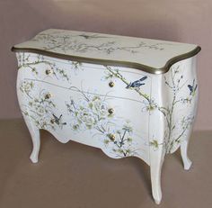 a white chest with flowers and birds painted on it