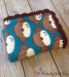 a blue and brown bear coin purse sitting on top of a wooden table