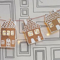 gingerbread houses are hung on a string with lights in the shape of house windows