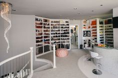 a room filled with lots of white furniture and walls covered in shelves full of items