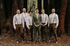 a group of men standing next to each other in front of trees