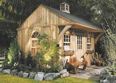 an image of a small wooden shed in the woods with plants and flowers around it