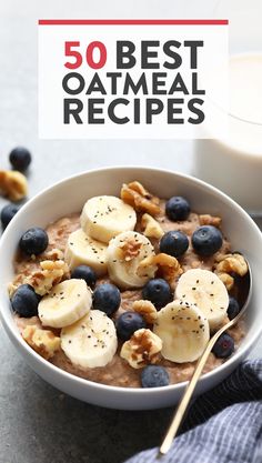 a bowl filled with oatmeal topped with bananas and blueberries next to a glass of milk