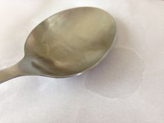 a silver spoon sitting on top of a white table