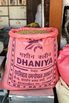 a large pink bag sitting on top of a metal box next to a pile of bags