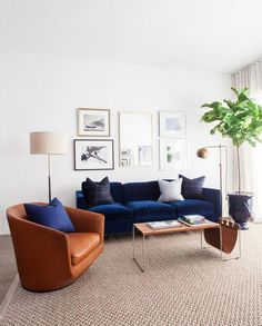 a living room with blue couches and pictures on the wall