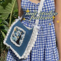 a woman wearing a blue and white dress holding a crocheted bag with a tree on it