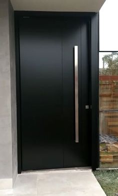 a modern black door in front of a house