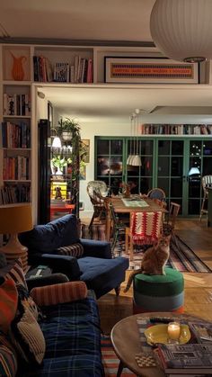 a living room filled with lots of furniture and bookshelves next to a fire place