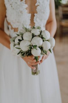 a woman in a white dress holding a bouquet of flowers