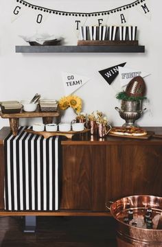 a football themed birthday party with black and white decorations, gold cups, and striped napkins