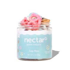 a jar filled with bath treats on top of a white surface