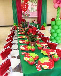 a table set up with plates, cups and vases for an apple themed birthday party