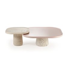 two white and pink tables sitting next to each other on top of a white surface