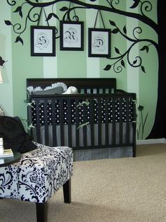 a baby's room decorated in black and white with a tree painted on the wall