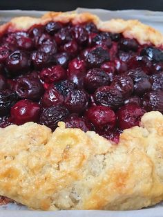 a close up of a pie with cherries on it