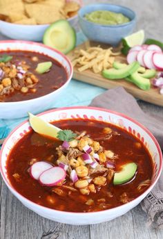 two bowls filled with chili, beans and avocado