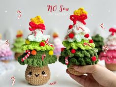 two small crocheted christmas trees with candy canes on top, one in the shape of a pine cone