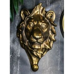 a metal lion head mounted to the side of a wall