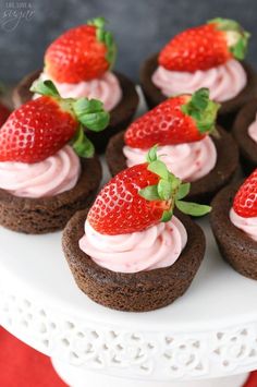 chocolate cupcakes with strawberry frosting and fresh strawberries on top are ready to be eaten