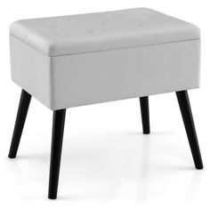 a white foot stool with black legs on a white background in front of a white backdrop