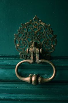 an old door handle on a green wooden door