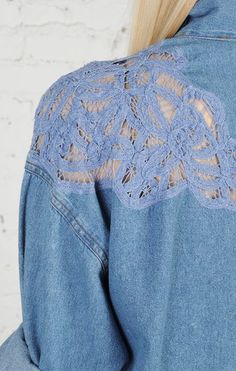 the back of a woman's denim jacket with crochet detailing