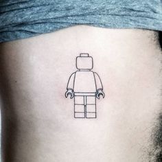 a small lego man tattoo on the stomach