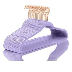 a purple plastic hanger with gold clips on it's end and another one in the background