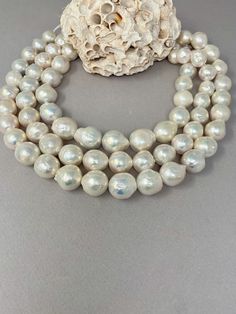 "These are Chinese freshwater nucleated pearls in a ripple shape. These beautiful pearls are an ivory white color with rainbow overtones.  They have amazing luster and shine.  They have a mostly smooth surface with some ripples.  These are graduated strands and range in sizes 12.5-17mm. Each strand is 16\" long and weights approx. 125g. Price is for one strand." White Akoya Pearl Necklace With High Luster, White High Luster Round Beads Pearl Necklace, White High Luster Pearl Necklace With Round Beads, Pearl White Mother Of Pearl Necklace With Round Beads, White Baroque Pearl Necklace With High Luster, White High Luster Pearl Necklace, Ivory White Color, Woman Jewelry, Pearl Strand