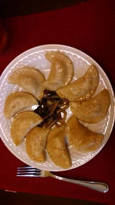 a white plate topped with sliced up bananas on top of a red table next to silverware