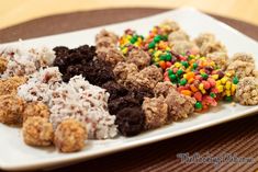 a white plate topped with lots of different types of candy bars and cereal krispy treats