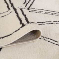 an area rug with black and white designs on it's edges, laying on the floor