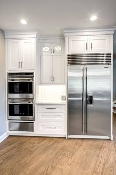 a kitchen with white cabinets and stainless steel appliances