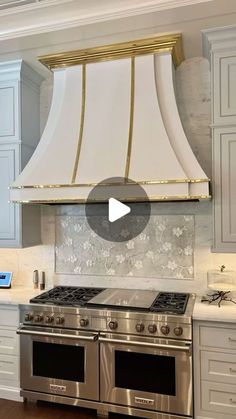 a stove top oven sitting inside of a kitchen next to white cupboards and drawers