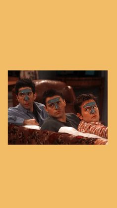 three men sitting in a chair with their faces painted like they are looking at something