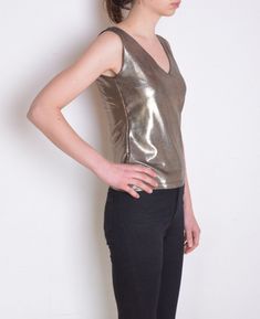 Cool vintage blouse made of unique fabric: shiny metallic textile in color that looks like a mix of silver and gold. Texture of tiny dots on almost invisible black background. Sleeveless, v neckline. Era: 90's, brand Hennes Fabric: 80% polyamide, 20% elasthane Condition: very good Estimated size: M / L (please, check the measurements) Measurements (measured flat, without stretching. Item is stretchy. Need to be doubled to get the circumference.): Chest: 42 cm / 16,5 inches Length: 55 cm / 21,6 i Metallic Shiny Chic Tops, Chic Metallic Shiny Tops, Glamorous Fitted Tops With Sheen, Glamorous Fitted Shiny Blouse, Fitted Metallic Summer Tops, Fitted Metallic Tops For Summer, Glamorous Metallic Sleeveless Top, Metallic Shiny Top For Party Season, Fitted Shiny Tops For Evening