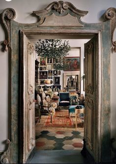 an open door leading to a living room filled with furniture and pictures on the wall