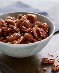 a bowl filled with nuts sitting on top of a table