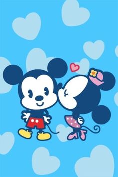 mickey and minnie mouse kissing in the air with hearts around them on a blue background