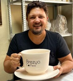 a man sitting at a table with a coffee cup