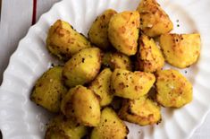 a white plate topped with fried potatoes on top of a table