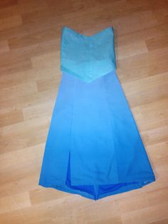 a blue dress laying on top of a wooden floor