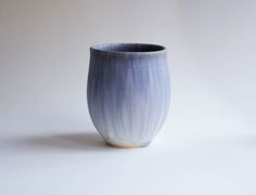 a blue and white vase sitting on top of a table next to a gray wall