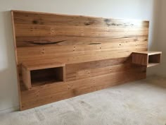 a bed made out of wood with built in shelves on the side and carpeted floor