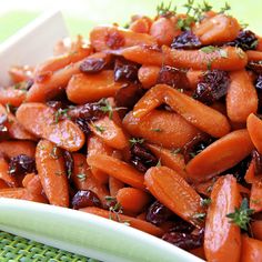 carrots with raisins and herbs in a white bowl