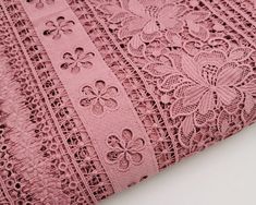 a pink lace fabric with flowers on it