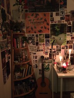 a room filled with lots of pictures and a guitar sitting on top of a desk