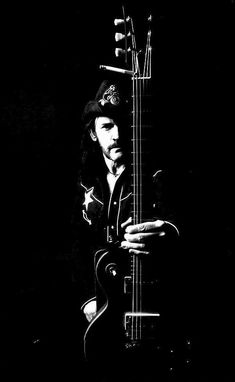 a black and white photo of a man holding a guitar